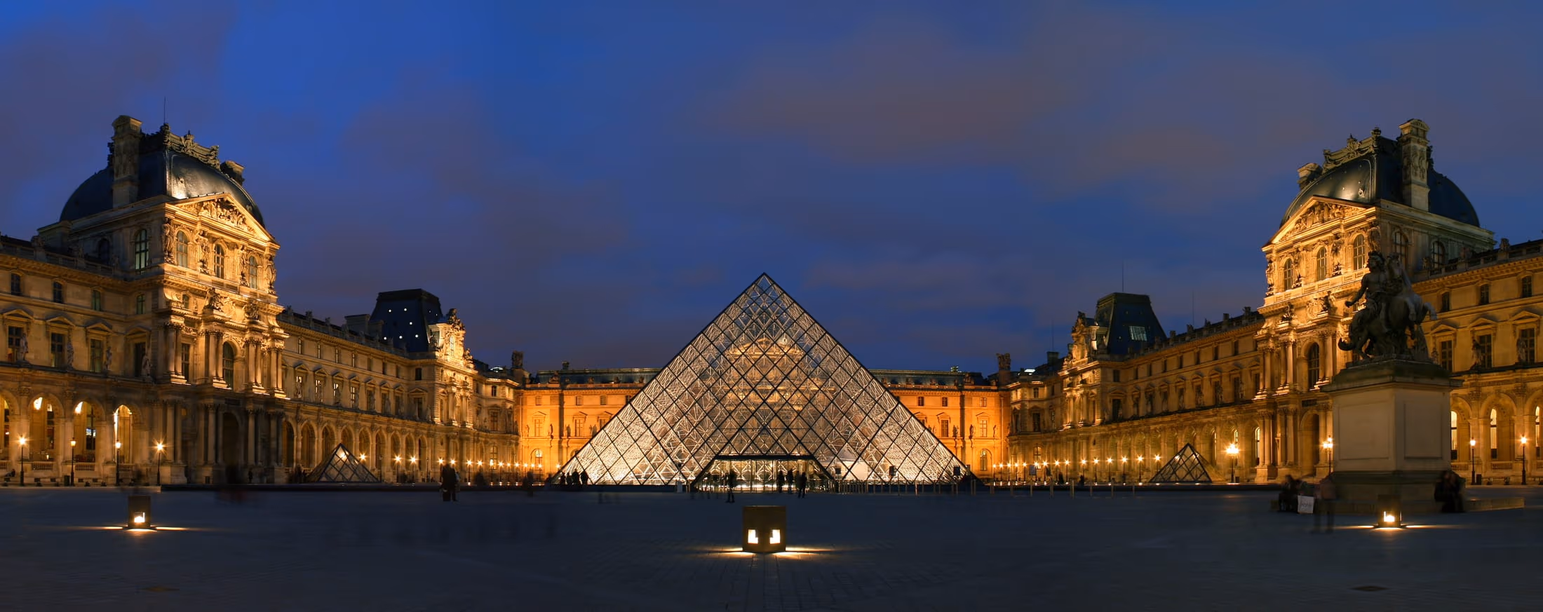 The Cour Napoléon and lit pyramid of the Louvre after dark