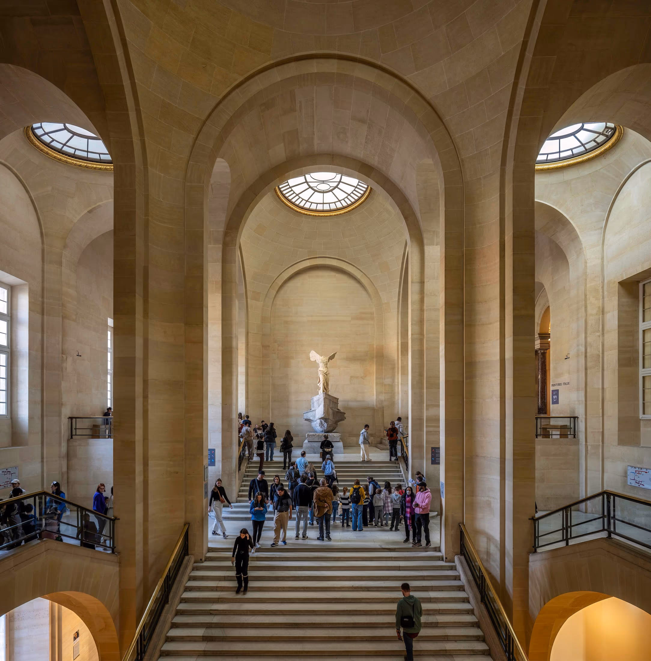 Visitors on the Daru staircase beneath the Winged Victory of Samothrace